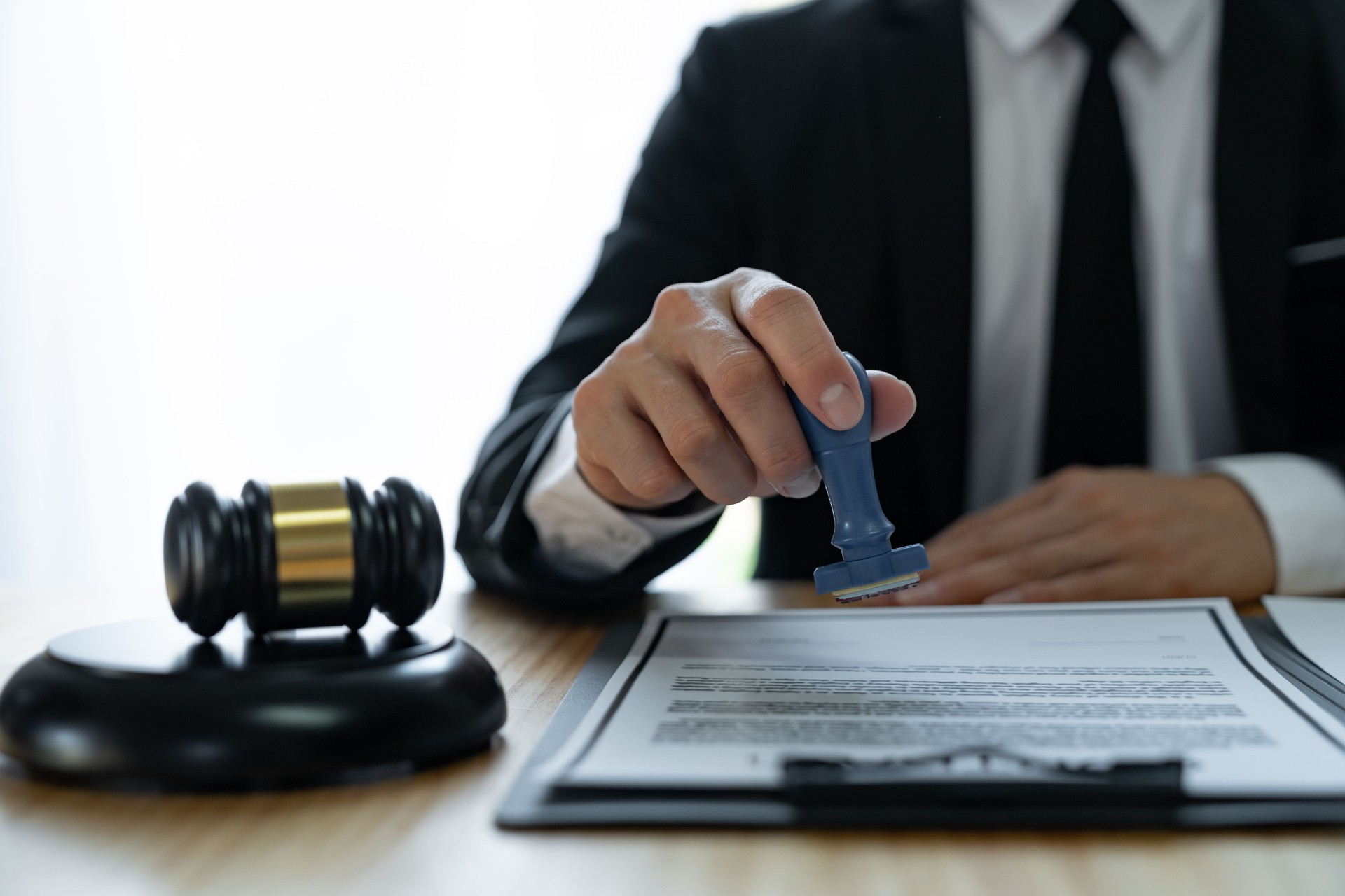 Young Asian legal advisor or lawyer doing document approval stamp Business agreements regarding real estate financial documents at the office.